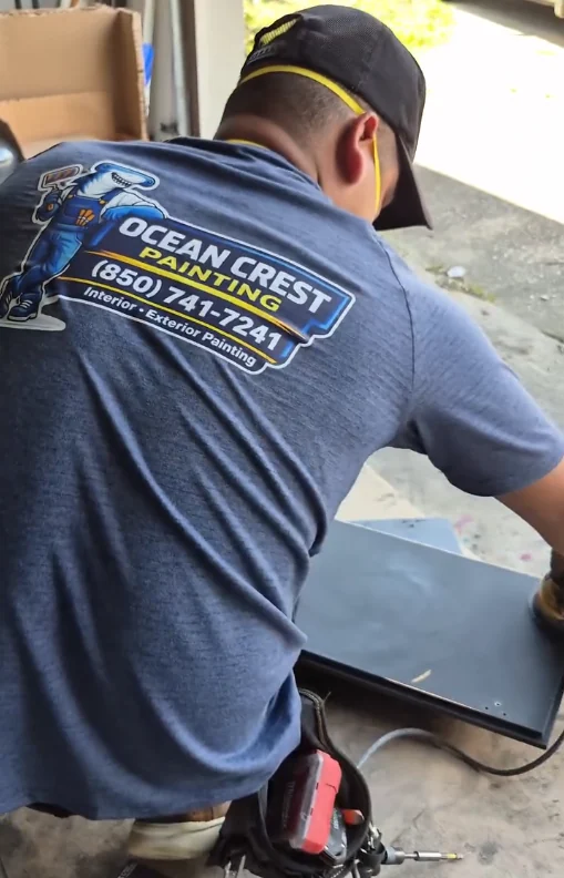 Ocean Crest Painting crew member wearing an Ocean Crest Painting shirt while prepping a surface
